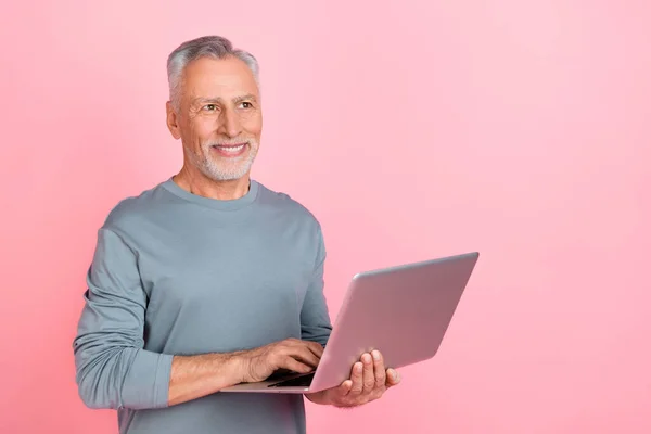 Foto do pensativo homem sonhador pensionista vestido camisa cinza segurando dispositivo moderno espaço vazio isolado cor de fundo rosa — Fotografia de Stock