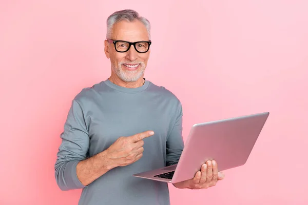 Foto de homem aposentado muito bonito usar óculos de camisa cinza apontando gadget moderno isolado cor-de-rosa fundo — Fotografia de Stock