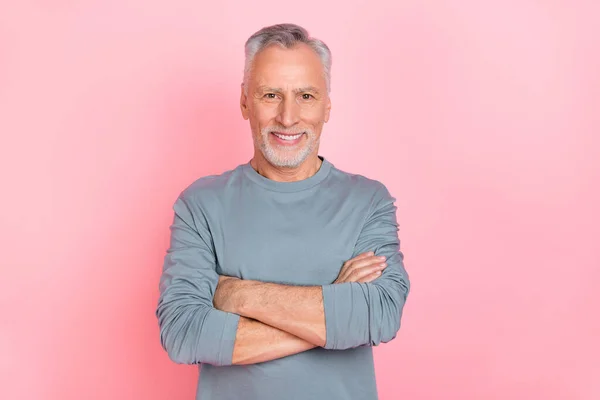 魅力的な魅力的な引退した男の写真は、グレーのシャツの腕を身に着けている孤立ピンク色の背景 — ストック写真