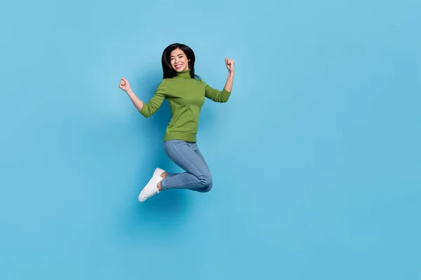 Ganzkörperfoto von hurra junge brünette Dame springen schreien tragen jumper jeans turnschuhe isoliert auf blauem hintergrund — Stockfoto