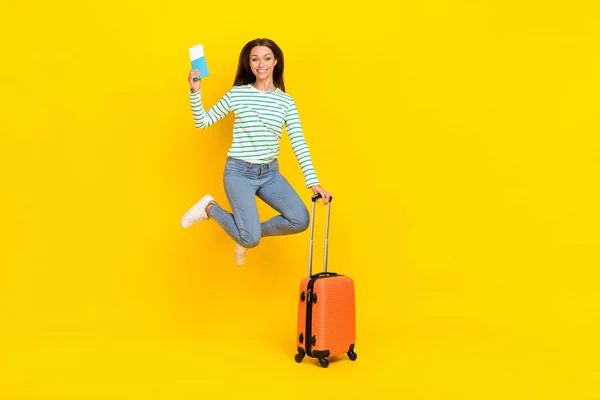 Foto in voller Länge von jungen fröhlichen Mädchen springen Dokumente Visum Check-in Registrierung fliegen isoliert über gelben Hintergrund — Stockfoto