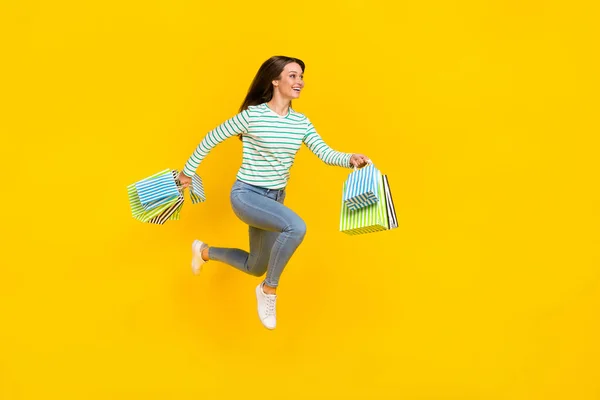 Full body profile side photo of young girl runner jumper rush shop look empty space isolated over yellow color background — Stock Photo, Image