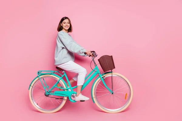 Foto lateral de perfil de longitud completa de la joven alegre chica disfrutar de viaje en bicicleta aislado sobre fondo de color rosa — Foto de Stock