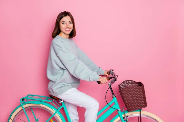 Profiel zijkant foto van de jeugd mooie dame genieten rijden fiets vrije tijd geïsoleerd over roze kleur achtergrond — Stockfoto