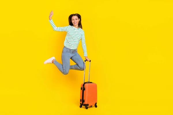 Ganzkörper-Foto von jungen schönen Mädchen springen Welle bye touristischen Flughafen Wochenende isoliert über gelben Farbhintergrund — Stockfoto