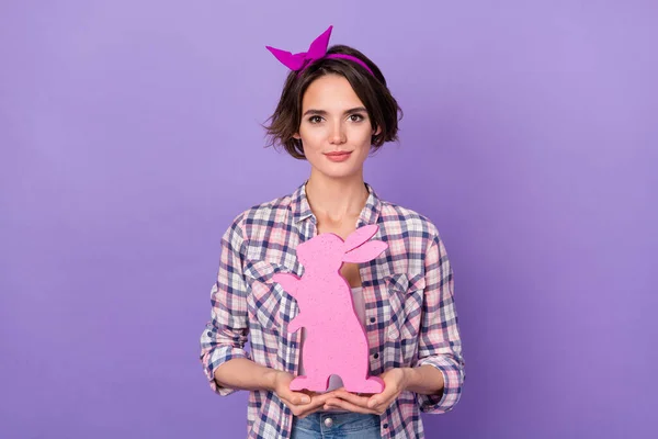 Foto di una donna piuttosto divertente indossare camicia a quadri tenendo le braccia rosa coniglio isolato colore viola sfondo — Foto Stock