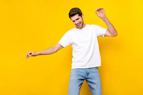 Foto do bonitinho milenar morena cara dança desgaste t-shirt jeans isolado no fundo de cor amarela — Fotografia de Stock