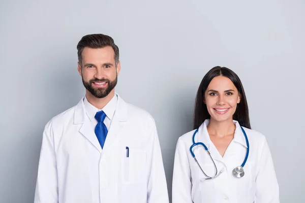 Foto de dos médicos amistosos positivos diagnóstico terapeuta mirada cámara aislada sobre fondo de color gris — Foto de Stock