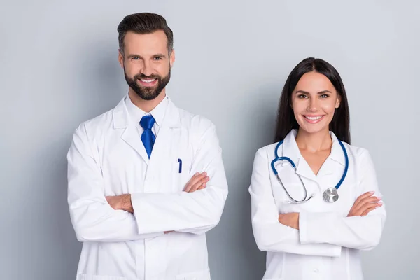 Foto de dos terapeutas inteligentes positivos brazos doblados sonrisa dentada mirada cámara aislada sobre fondo de color gris — Foto de Stock