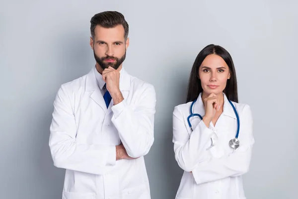 Foto de ponder pensativo dos médicos usan abrigos blancos manos brazos barbilla aislado color gris fondo — Foto de Stock