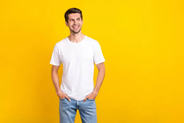 Photo of interested millennial brunet guy look promo wear casual cloth isolated on yellow color background —  Fotos de Stock
