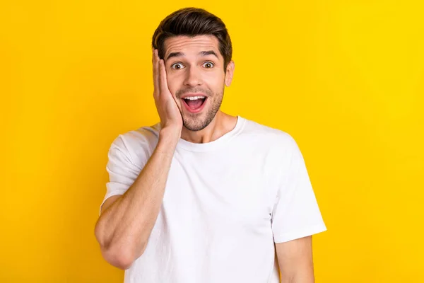 Photo of impressed millennial brunet guy palms face wear white t-shirt isolated on yellow color background — Stok fotoğraf