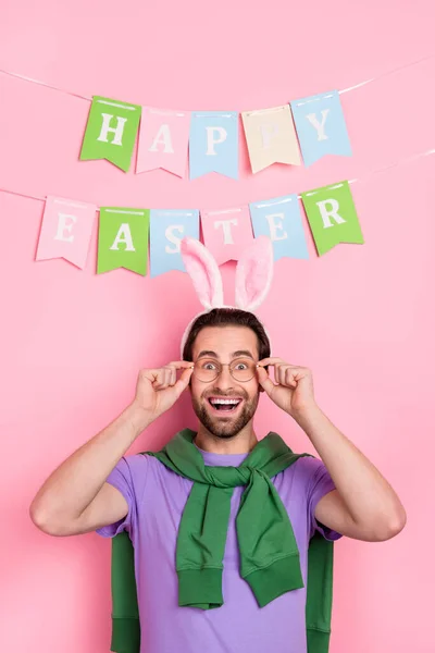 Zdjęcie pod wrażeniem dobry nastrój człowiek świętować Wielkanoc wakacje nosić śmieszne opaski izolowane na różowym tle kolor — Zdjęcie stockowe