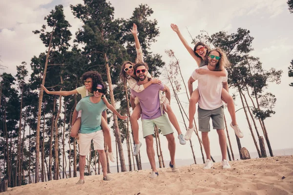 Foto de doce amigável seis jovens amigos vestidos roupas casuais andando segurando braços piggyback ao ar livre campo — Fotografia de Stock