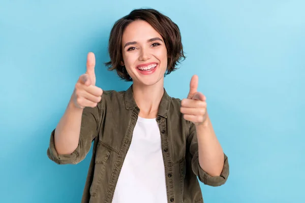 Photo of sweet millennial Bob hairdo lady index kamera viselni khaki ing elszigetelt kék színű háttér — Stock Fotó