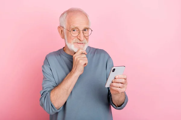 Photo positive délicate gars pensionné habillé gris pullover lunettes lecture dispositif moderne isolé fond de couleur rose — Photo
