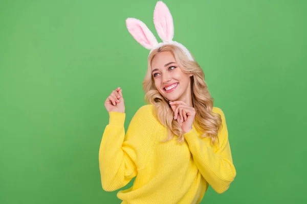 Foto von optimistischen Millennial blonde Dame aussehen Promo Tanz tragen Ohren gelben Pullover isoliert auf grünem Hintergrund — Stockfoto