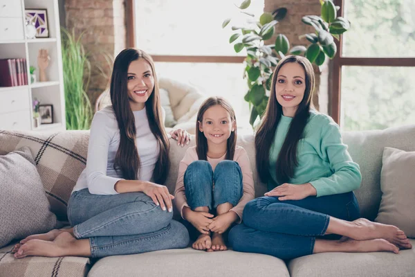 Полноразмерное фото привлекательных девушек, сидящих диван гостиная наслаждаться свободное время вместе братья и сестры материнство в помещении — стоковое фото