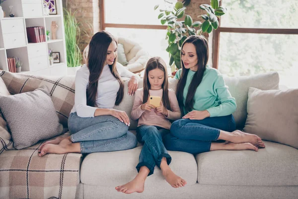 Полное фото тела мамы и девочек смотреть читать просматривать сотовый телефон социальная сеть пост сидя диван в помещении — стоковое фото