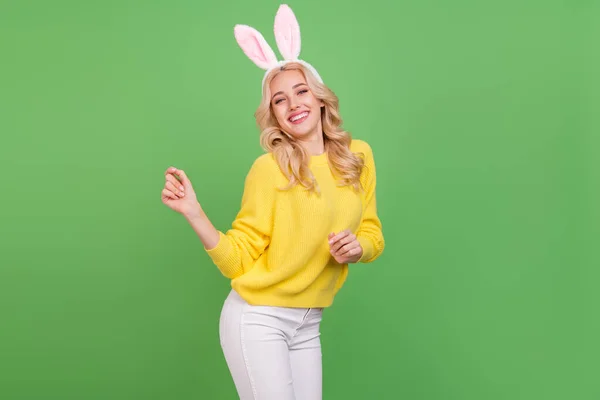 Foto de doce jovem loira senhora dança desgaste orelhas amarelo pulôver calças isoladas na cor verde fundo — Fotografia de Stock