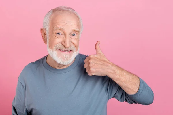Fotografie sebevědomí legrační důchodce šedý svetr ukazující palec nahoru izolované růžové barvy pozadí — Stock fotografie