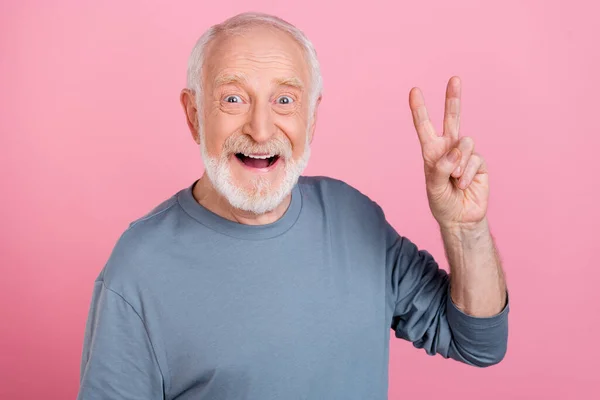 Zdjęcie śmieszne wrażenia emeryta szary sweter pokazujący v-sign odizolowany różowy kolor tła — Zdjęcie stockowe