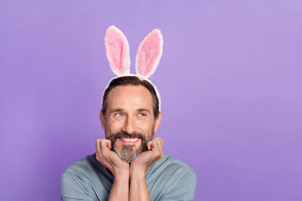 Nahaufnahme Bild von lustig süß aussehenden Mann mit Hasenohren suchen leeren Raum isoliert auf violettem Hintergrund — Stockfoto