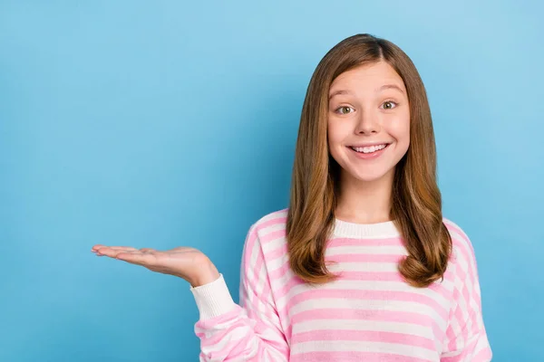 Foto van funky kleine meisje houden lege ruimte slijtage gestreept shirt geïsoleerd op blauwe kleur achtergrond — Stockfoto