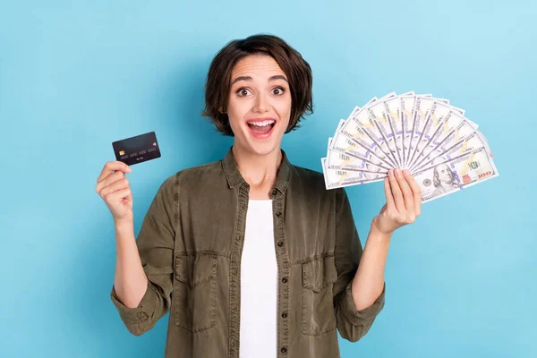 Fénykép a hurrá fiatal rövid frizura lady hold money card wear khaki ing elszigetelt kék színű háttér — Stock Fotó