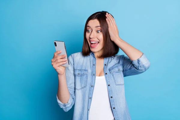 데님 셔츠를 입고 웃는 당황 한 여인의 사진빈 공간에 고립된 푸른 색 배경 — 스톡 사진