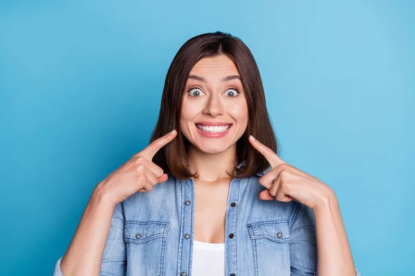 Foto de mulher engraçada impressionado usar jeans camisa apontando dedos dentes isolado azul cor fundo — Fotografia de Stock