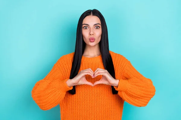 Foto de mulher muito engraçada usar camisola laranja enviando beijo mostrando braços coração isolado cor turquesa fundo — Fotografia de Stock