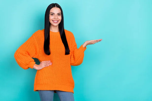 Foto de dulce adorable joven dama vestida de punto suéter sosteniendo brazo vacío espacio aislado color verde azulado fondo —  Fotos de Stock