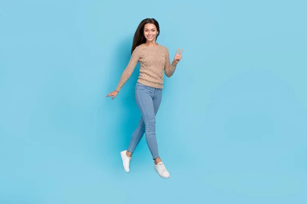 Full length body size view of attractive cheery cute girl jumping showing v-sign isolated over bright blue color background — Stock Photo, Image