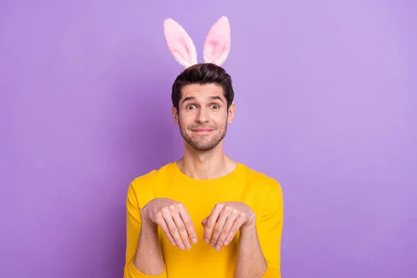 Porträt der guten Laune lustiger junger Mann mit Hasenohren herumalbern benehmen sich wie Kaninchen isoliert auf violettem Hintergrund — Stockfoto