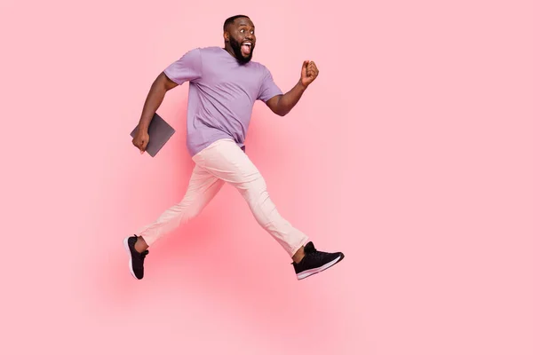 Foto de cara impreesed animado usar t-shirt roxa saltando alta segurando moderno dispositivo isolado cor de fundo rosa — Fotografia de Stock