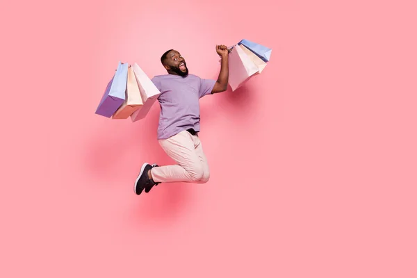 Plná délka tělo velikost pohled na atraktivní veselý šťastný chlap skákání držení dárky izolované přes růžové pastelové barvy pozadí — Stock fotografie