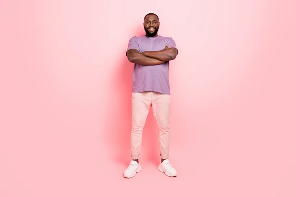 Foto van positieve mooie man dragen paarse t-shirt armen gekruist glimlachen geïsoleerde roze kleur achtergrond — Stockfoto