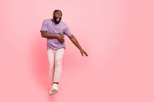 Foto de chico bastante dulce usar púrpura camiseta bailando espacio vacío aislado color rosa fondo — Foto de Stock
