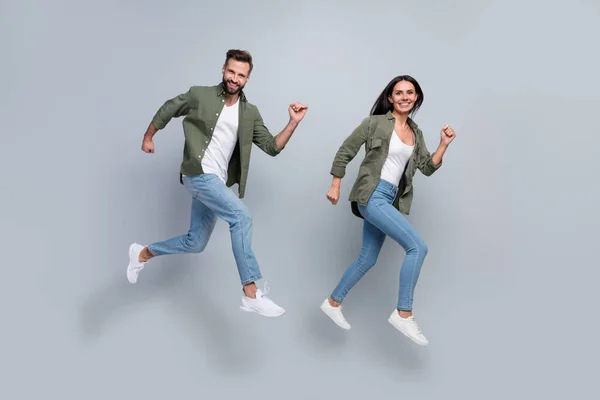 Foto de comprimento total de mulher cara cônjuges salto correr velocidade rápida pechincha isolado sobre fundo de cor cinza — Fotografia de Stock