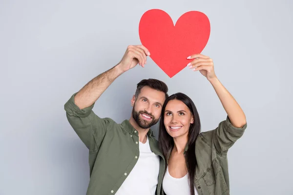 Retrato de casal alegre atraente abraço segurando romance cartão de coração 14 Fevereiro isolado sobre fundo de cor pastel cinza — Fotografia de Stock