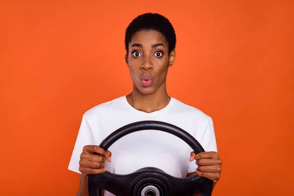 Foto van verrast androgyne dame bestuurder houden stuurwiel dragen stijlvolle t-shirt geïsoleerde glans kleur achtergrond — Stockfoto
