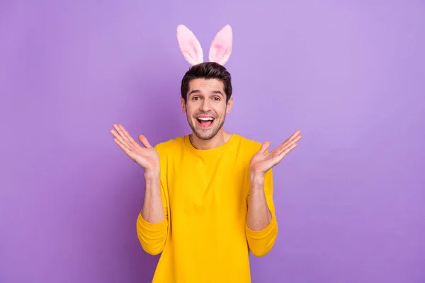 Foto van goed humeur jong knap mannetje hebben plezier dragen konijn oren vieren Pasen geïsoleerd op paarse kleur achtergrond — Stockfoto