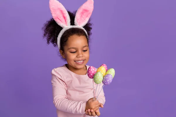 Retrato de atraente pequena menina pré-adolescente na moda segurando ovos de artesanato isolado sobre fundo de cor violeta roxo brilhante — Fotografia de Stock