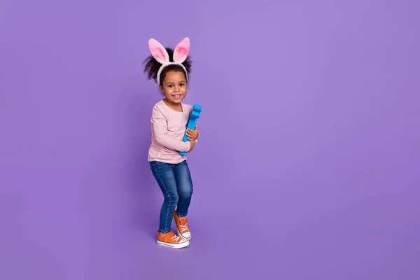 Vista completa del tamaño del cuerpo de la atractiva alegre pre-adolescente gir jugando espacio de copia de conejo aislado sobre el fondo violeta brillante color violeta — Foto de Stock