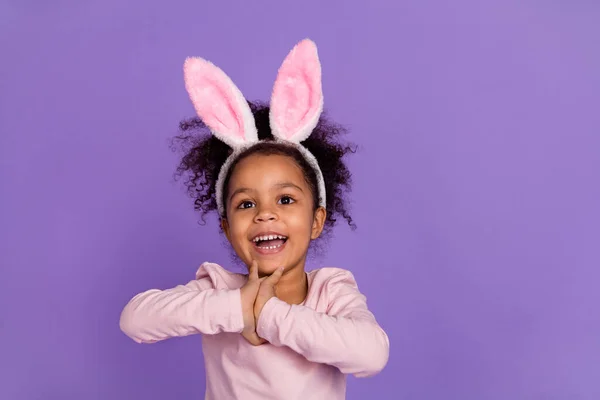 Portret van aantrekkelijke vrolijke schattig verbaasd pre-teen meisje dragen konijnenoren hebben plezier geïsoleerd over heldere paarse paarse kleur achtergrond — Stockfoto