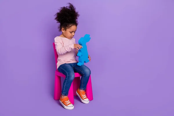 Повнометражний вигляд на тіло привабливої модної дівчини, яка грає фестну іграшку, ізольовану на яскраво-фіолетовому фіолетовому кольоровому фоні — стокове фото