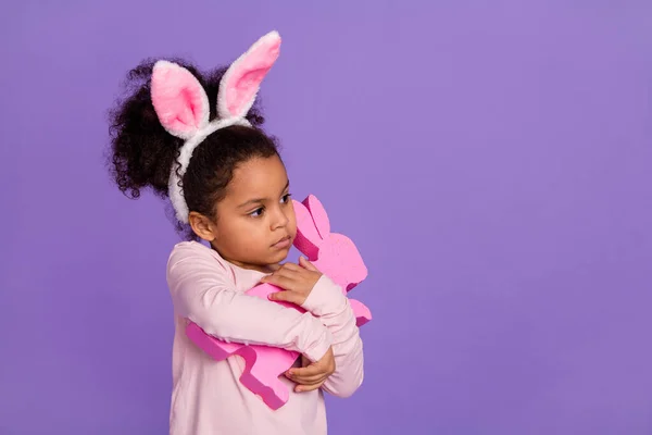 Retrato de la atractiva chica preadolescente de moda abrazando la tienda de juguetes de conejito, espacio de copia aislado sobre un fondo de color violeta brillante — Foto de Stock