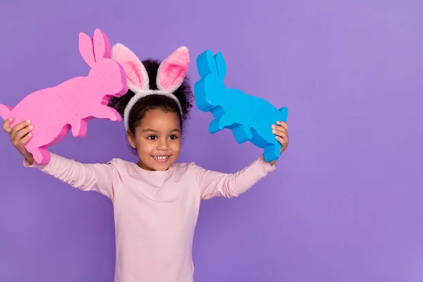 Retrato de la atractiva niña preadolescente alegre sosteniendo conejos jugando juguetes aislados sobre el fondo violeta brillante color violeta — Foto de Stock