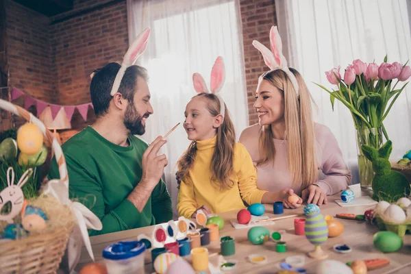 Portret pięknej, wesołej rodziny przygotowującej imprezę rysującą jajka bawiące się rozrywką w pomieszczeniach — Zdjęcie stockowe